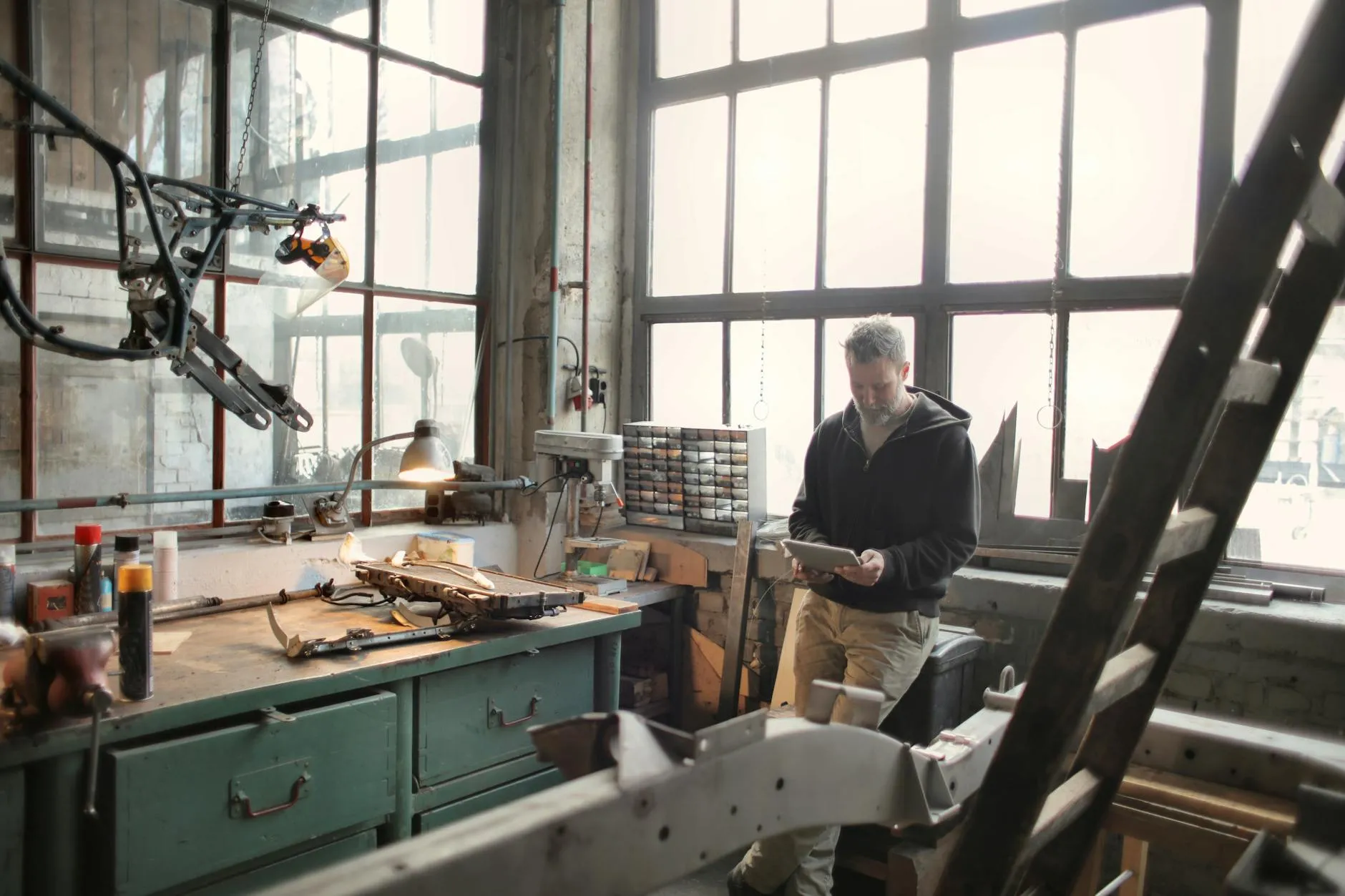 Handwerker mit Tablet in der eigenen Werkstatt — die Schnittstelle zwischen Handwerk und digitaler Präsenz, die eine gute Website für Handwerker braucht