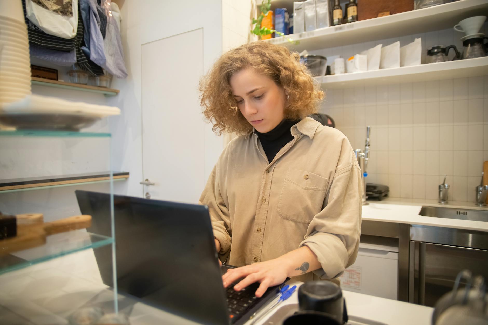 Inhaberin richtet am Laptop in ihrem Café das Google-Unternehmensprofil Schritt für Schritt ein