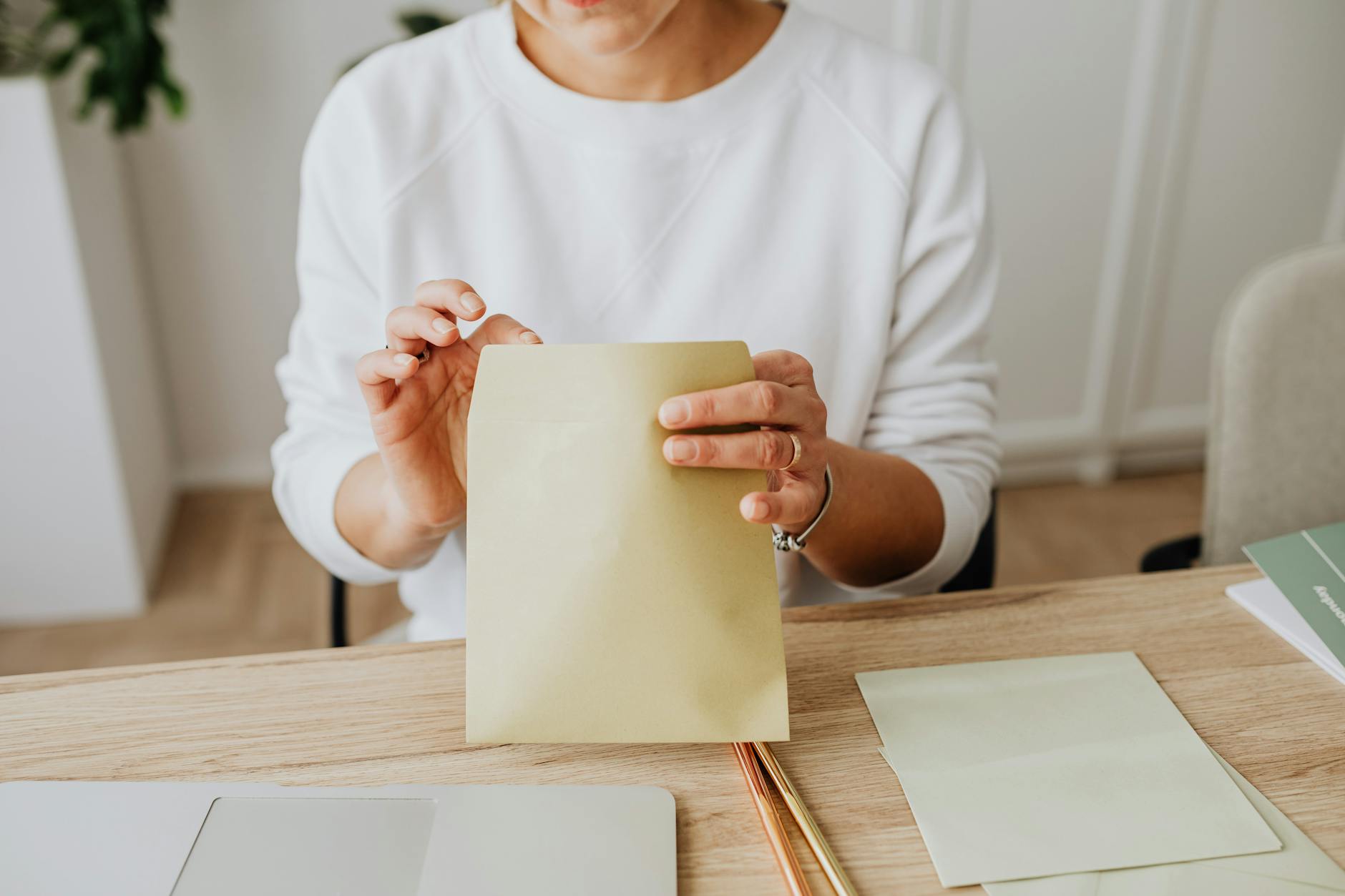 Geschäftsinhaberin mit Briefumschlag am Schreibtisch — bei der Verifizierung per Postkarte schickt Google den Code per Post